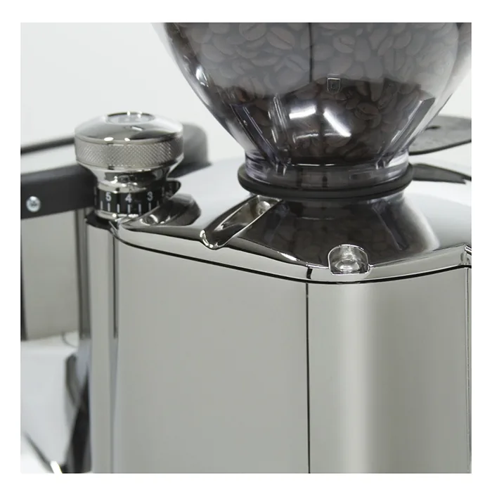 The Rocket Espresso Macinatore FAUSTO Chrome grinding directly into a portafilter, demonstrating its hands-free operation