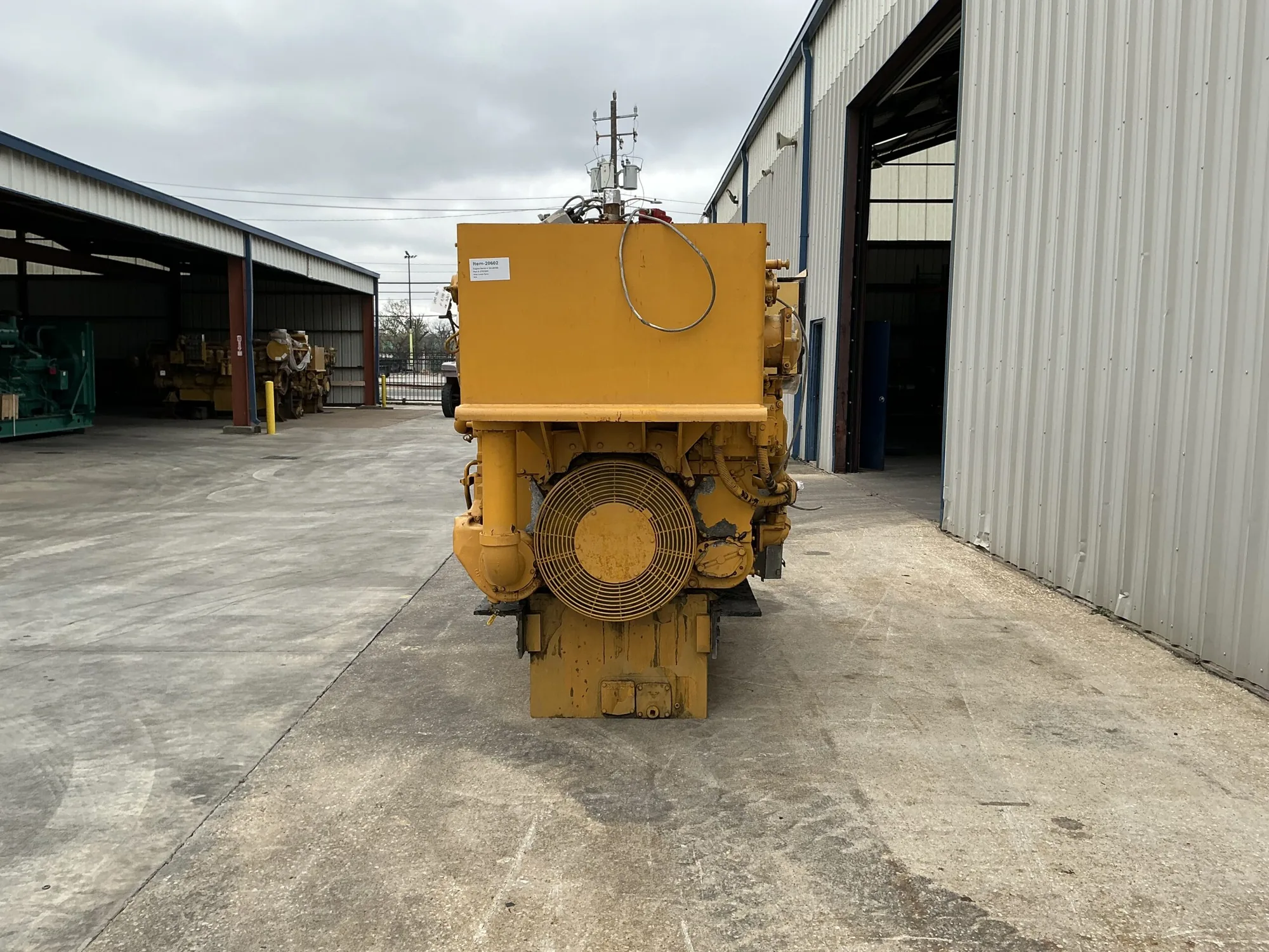 Yellow industrial generator set with a large circular front cooling fan