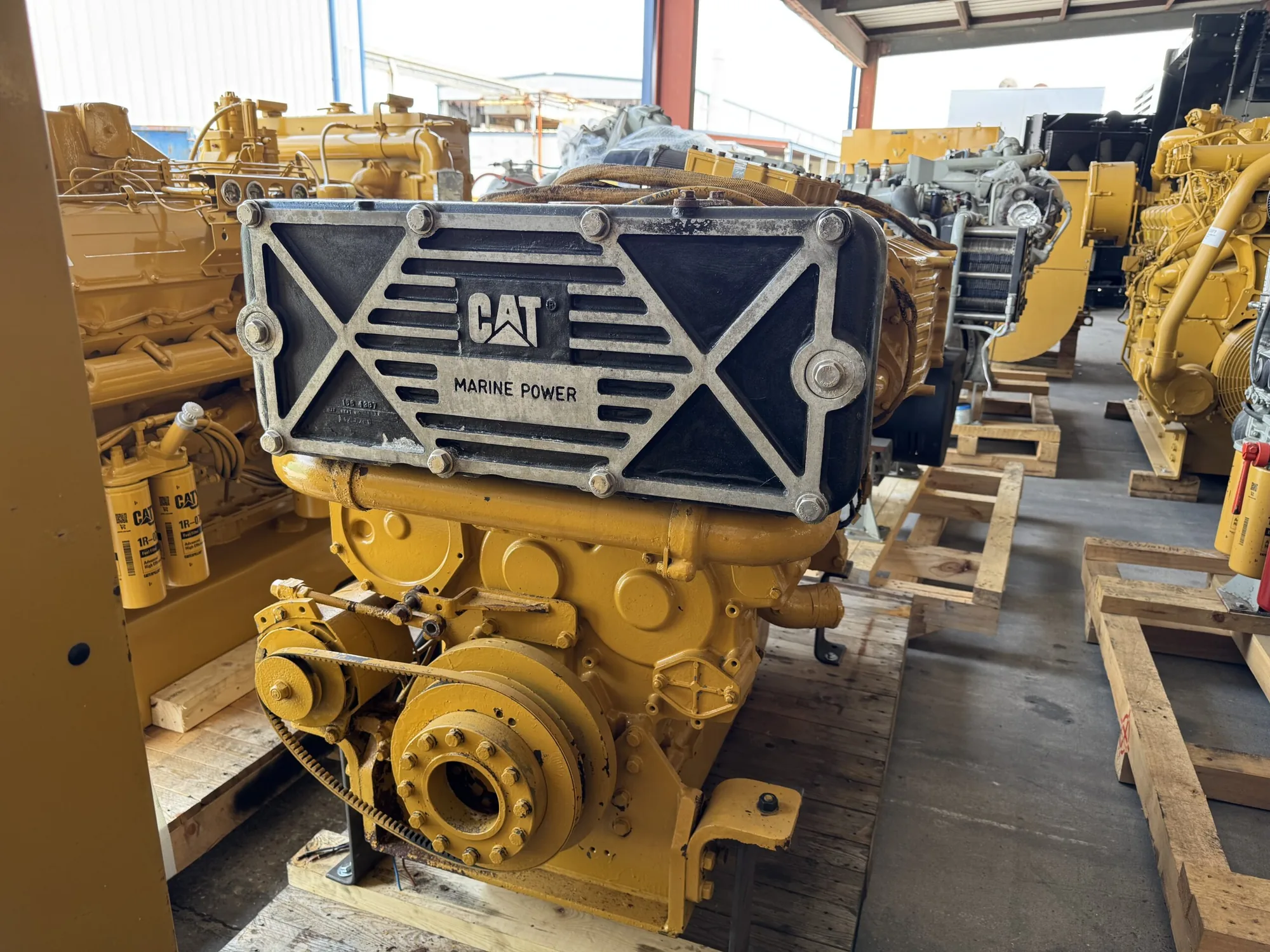 CAT Marine Power engine; front panel displays CAT and MARINE POWER, featuring a black X-pattern grille and bolted corners on a yellow frame
