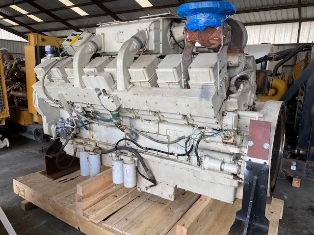 Large industrial diesel engine with a blue protective cap on top and visible fuel filters along the side
