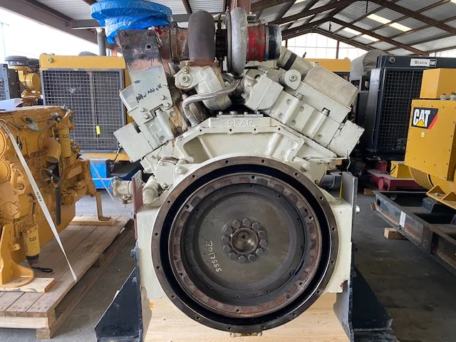 Large industrial diesel engine block, front view showing a circular flywheel housing with a bolt ring; REAR cast into the top of the block