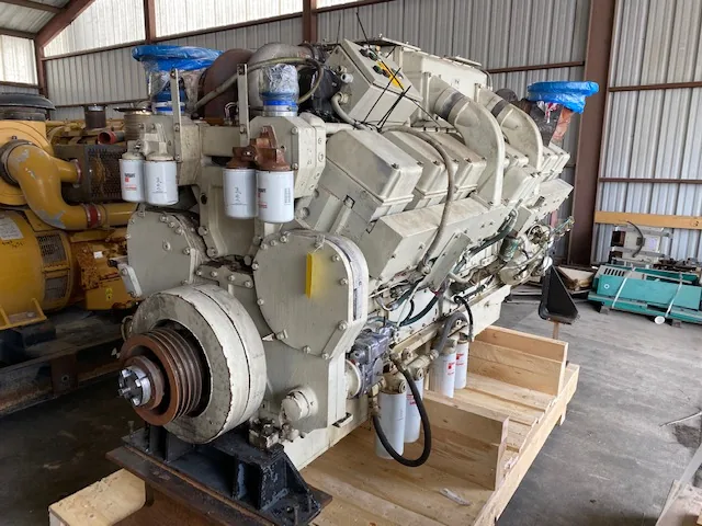Industrial diesel engine mounted on a wooden skid, featuring multiple filters along the sides and a large front pulley